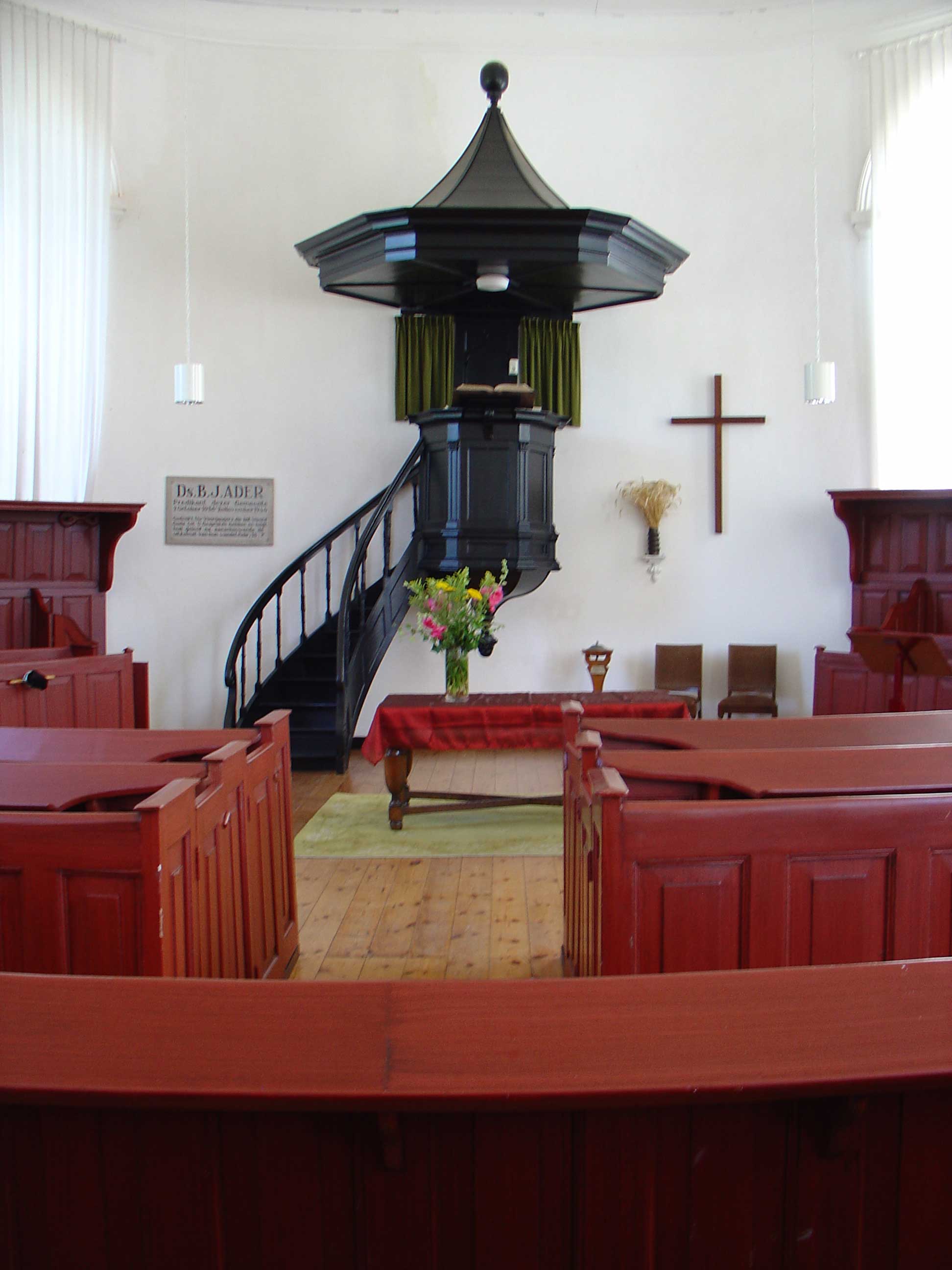 Interieur van de kerk met herdenkingsbord voor ds B.J. Ader.